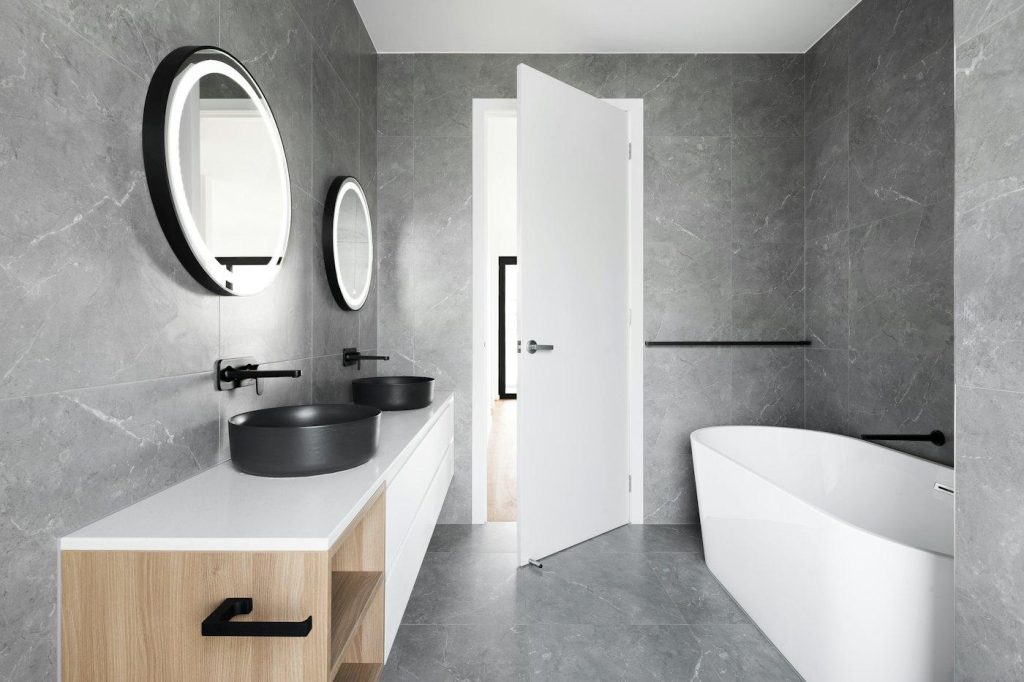 Modern bathroom with gray tile and a floating wood vanity