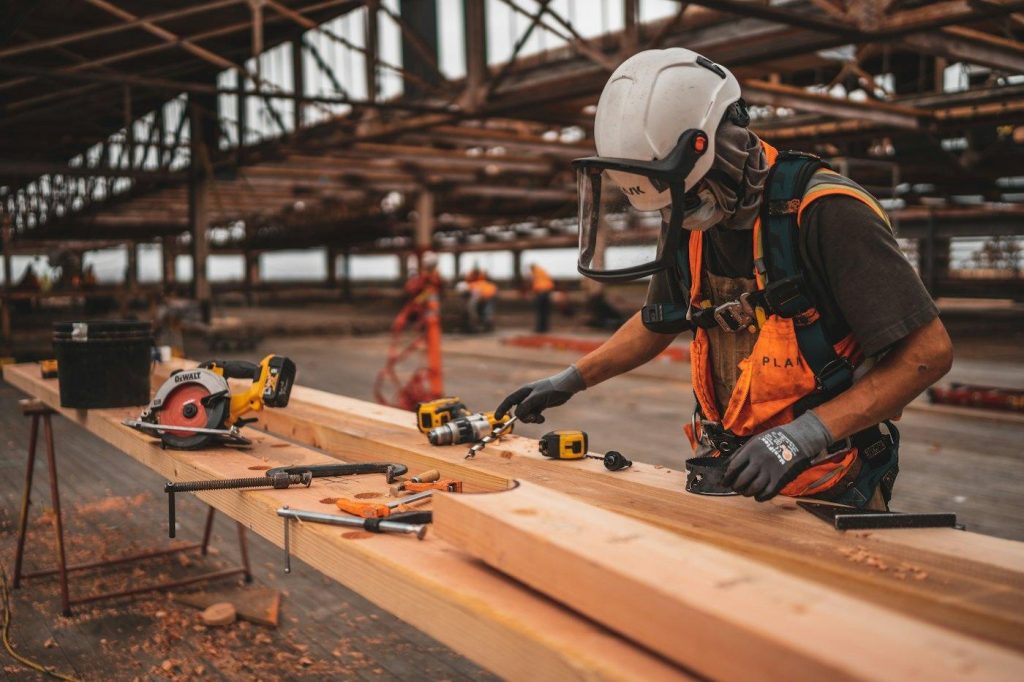 Contractor measuring and cutting lumber on a job site