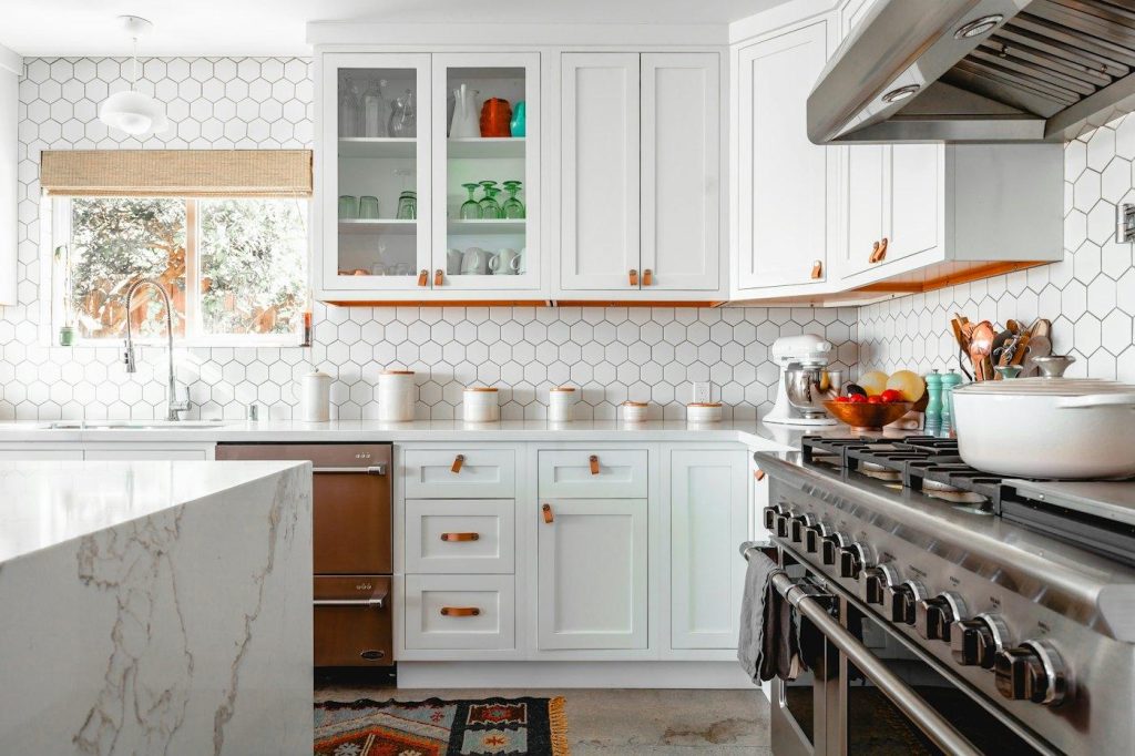 White kitchen with marble island and range hood