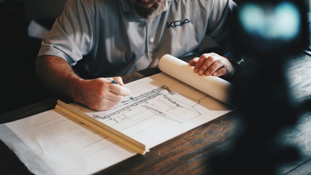 Contractor sketching project plans at a table